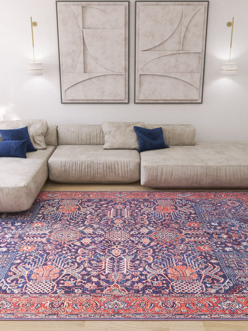 Load image 1 in gallery view. A modern living room with a beige sectional sofa, blue pillows, abstract wall art, and the Solstice Red Navy Washable Rug (LCC3026) in a custom size—its red and blue patterns are ideal for high-traffic wooden floors.