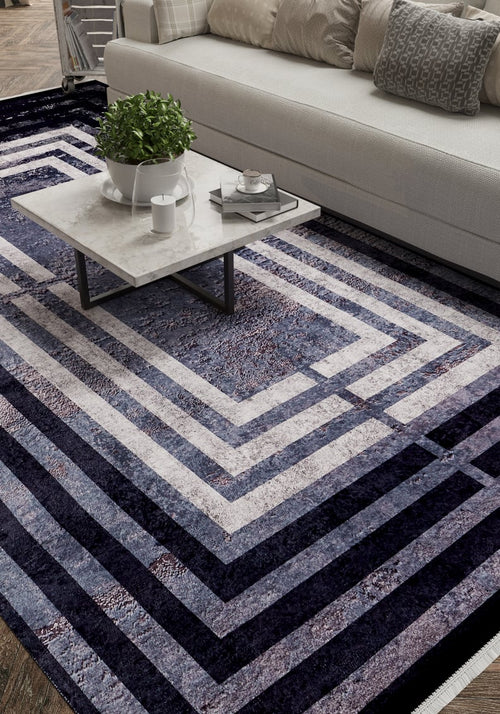 Load image 1 in gallery view. A modern living room with a white sofa, textured pillows, a marble coffee table with a plant and tray, and the Sophisticated and Chic - Washable Rug - JR1409 (Custom Size) in geometric blue, gray, and white—ideal for busy spaces.