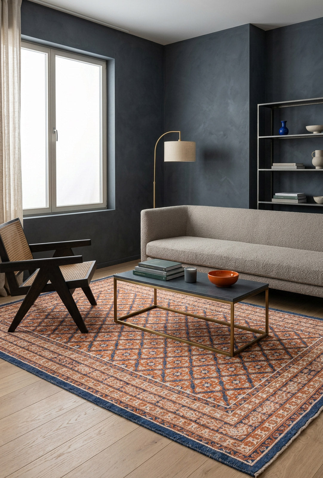 Rust and navy blue rug with a geometric diamond pattern, styled in a modern living room with dark walls.
