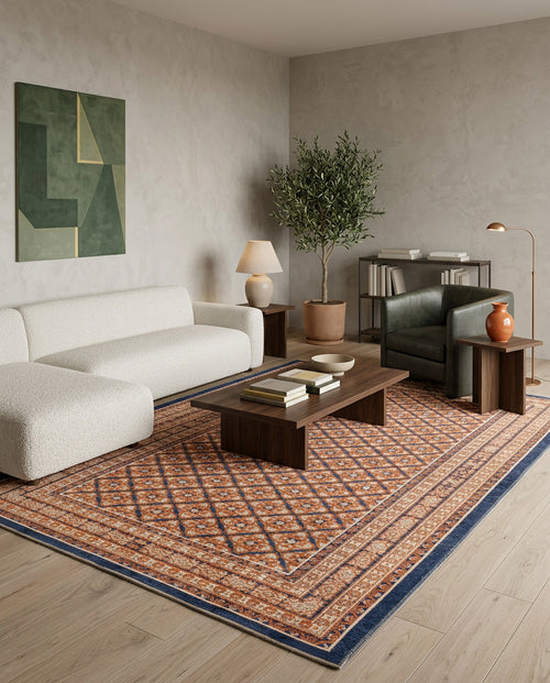 Load image 1 in gallery view. Rust and blue traditional rug with a geometric diamond pattern, styled in a modern living room.