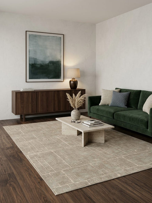 Load image 1 in gallery view. Beige rug with a subtle grid pattern, styled in a modern living room with a green sofa and dark wood furniture.