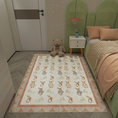 Load image 1 in gallery view. Cream rug with a repeating pattern of rabbits and carrots, featuring a peach-toned geometric border in a child's bedroom.