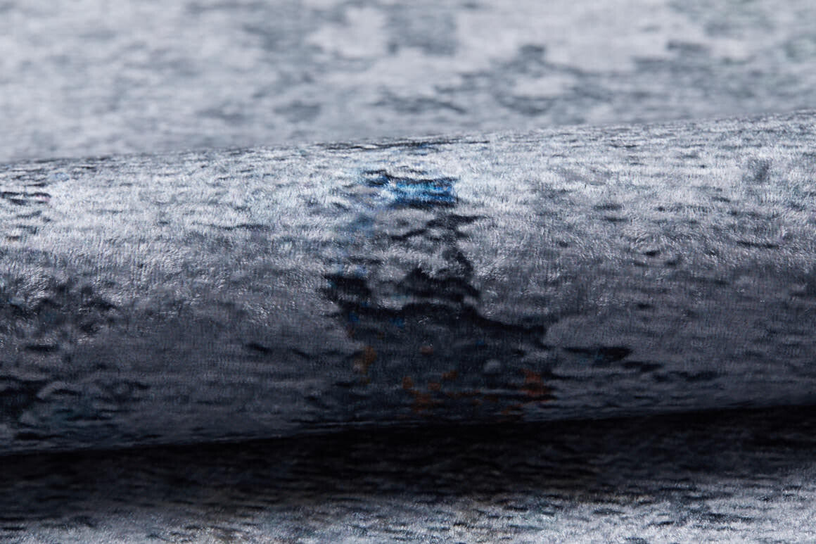 A close-up showcases the Striking Statements - Washable Rug - JR786 (Custom Size) in textured metallic gray with blue and dark accents, featuring a soft velvety surface and a reflective sheen.