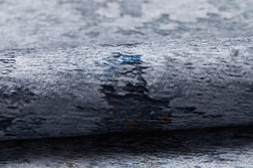Load image 1 in gallery view. A close-up showcases the Striking Statements - Washable Rug - JR786 (Custom Size) in textured metallic gray with blue and dark accents, featuring a soft velvety surface and a reflective sheen.