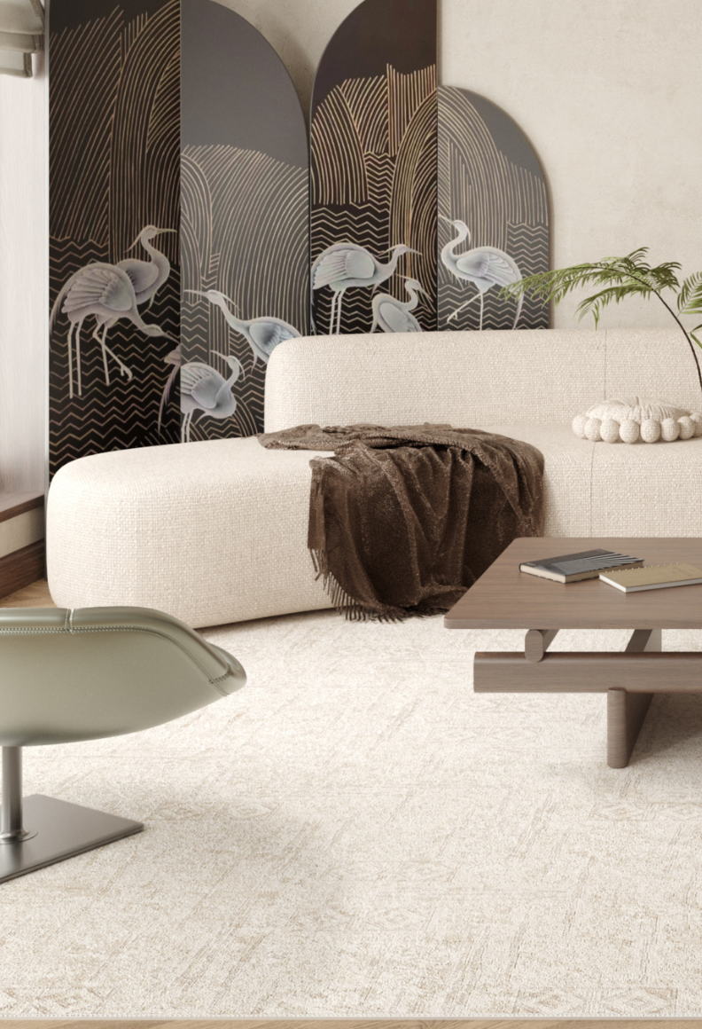 A modern living room with a curved white sofa, brown throw, light green swivel chair, wooden coffee table with books, and a crane screen—all atop the Sunset Fade - Washable Rug - JR1878 (Custom Size) for added warmth.