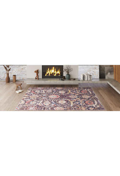 Load image 1 in gallery view. A modern living room with a lit fireplace, decorative mantle objects, and the Sylvanor Colorful Washable Rug - LCC3017 in purple and gold tones—ideal for high-traffic areas—on a light wooden floor.