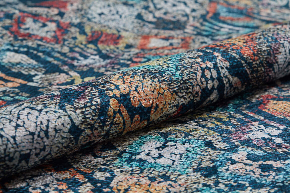 A close-up of the Tarnished Elegance - Washable Rug - JR1095 (Custom Size), showcasing its intricate multicolored abstract pattern in blue, orange, red, and cream. The detailed weave is visible—durable and ideal for high-traffic areas.