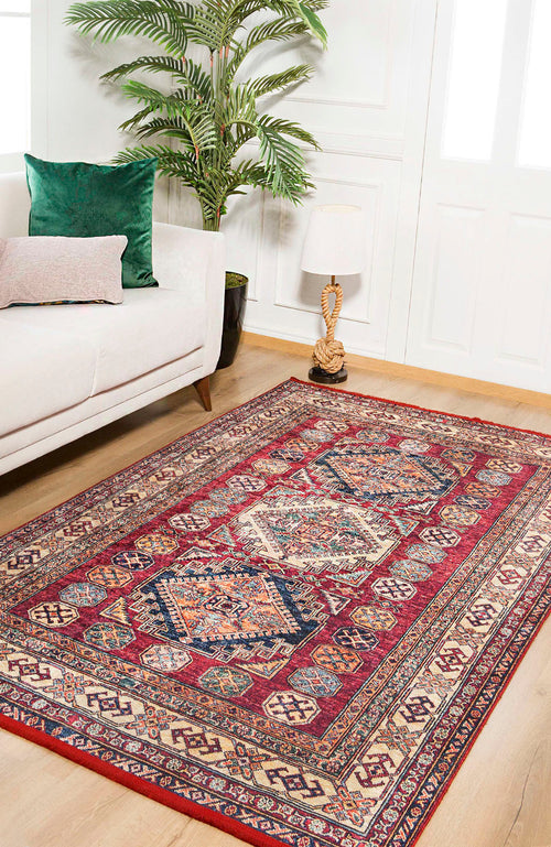 Load image 1 in gallery view. A living room with a white sofa, green and pink cushions, a plant, a lamp on a side table, and the Time-Honored Textures - Washable Rug - JR40 (Custom Size) with geometric designs—perfect for high-traffic wooden floors.