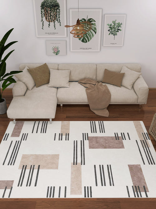 Bild 1 in Galerieansicht laden. A modern living room featuring the Timeless Scroll - Washable Rug - JRN45, a beige sectional, brown and beige cushions, a tan throw, green plants, wall art—ideal for high-traffic contemporary spaces with its black and brown geometric pattern.