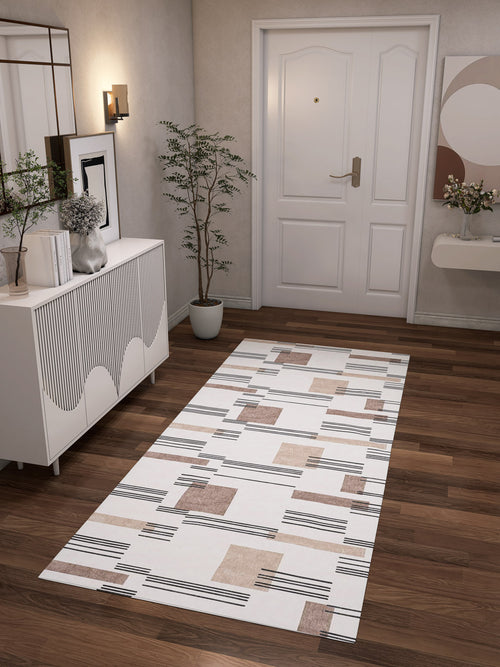 Bild 1 in Galerieansicht laden. A modern hallway with a dark wooden floor, white door, and white furniture features the Timeless Scroll - Washable Rug - JRN45. Decorative plants, wall art, a mirror, and soft lighting complete this cozy space—ideal for high-traffic areas.