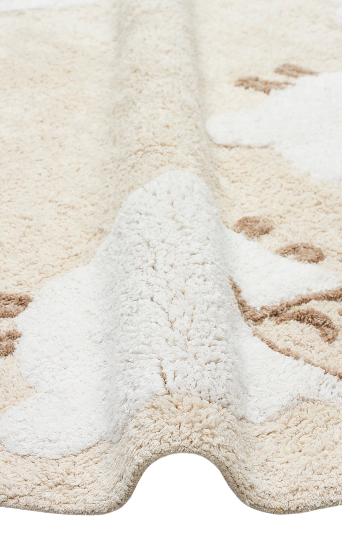 A close-up of the Tiny Motion - Washable Shaggy - CBN11 rug shows its soft, cream-colored cotton shag with raised areas and white and brown patterns, creating a gentle wavy effect across the surface.