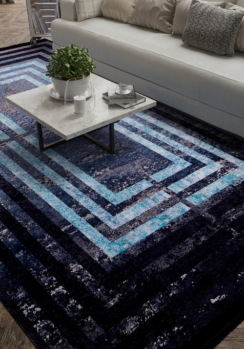 Bild 1 in Galerieansicht laden. A modern living room with a white sofa, gray and white cushions, a marble coffee table, and the Traditional and Timeless - Washable Rug - JR1408—a blue geometric rug perfect for high-traffic areas. A potted plant and tray with cups rest on the table.