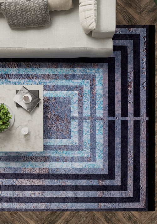 Load image 1 in gallery view. A top-down view of a living room with a gray sofa, marble coffee table with a plant and drinks, and the Traditional and Timeless - Washable Rug - JR1408 (Custom Size) in black and blue on dark wood flooring—ideal for high-traffic areas.