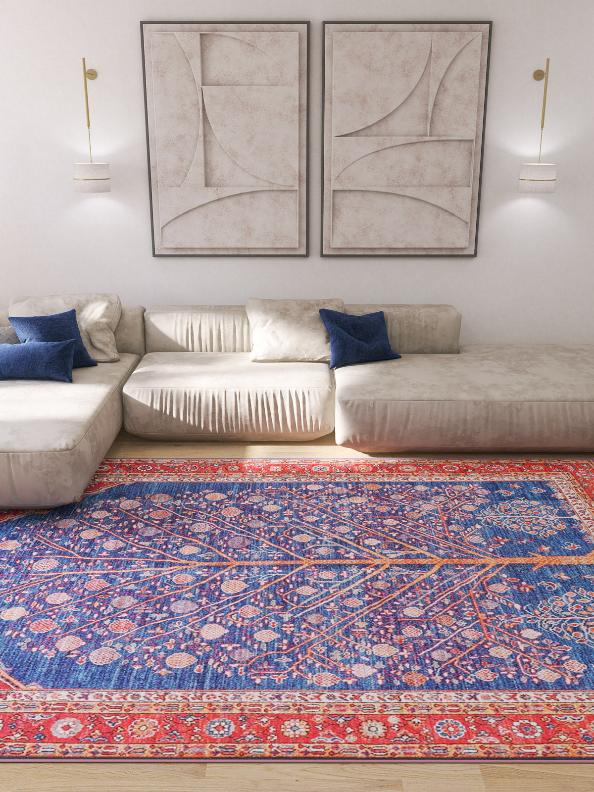 A modern living room with light beige sectional sofas, blue accent pillows, abstract art, and the Tree of Plenty Red Blue Washable Rug (LCC3031)—perfect for high-traffic areas and allergy-sensitive households.