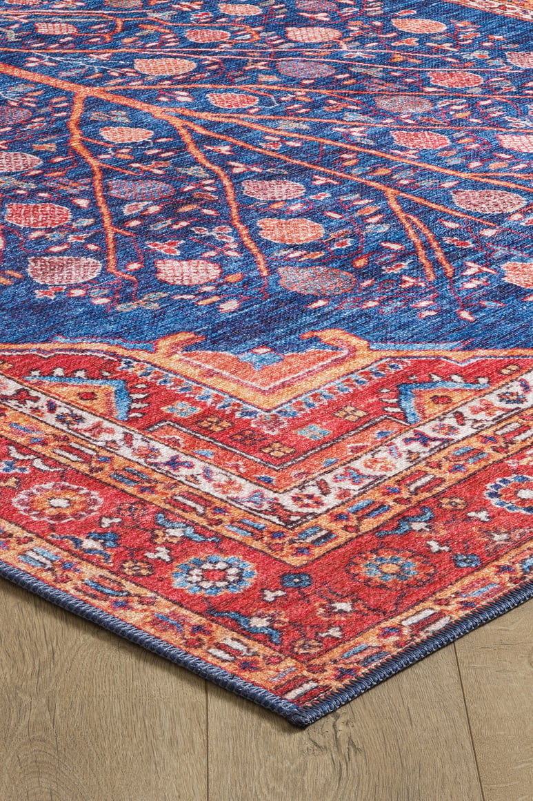 A close-up of the Tree of Plenty Red Blue Washable Rug (LCC3031, Custom Size) shows its vibrant geometric border and floral-vine patterns—ideal for allergy-sensitive homes and durable in high-traffic spaces on light wood floors.
