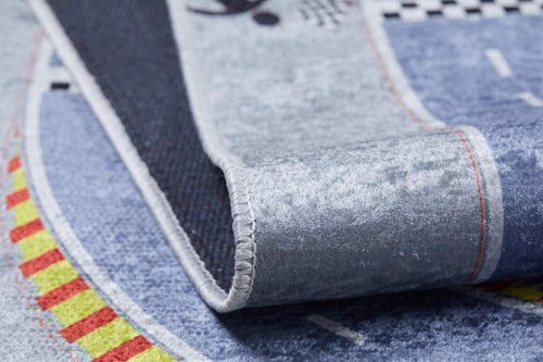 Load image 1 in gallery view. Close-up of the Turbo Tracks - Machine-Washable Rug JRC089 (Custom Size) play mat, featuring blue, yellow, red, and black patterns with roads. Slightly curled to show stitched edges and textured backing; durable flat-weave surface.