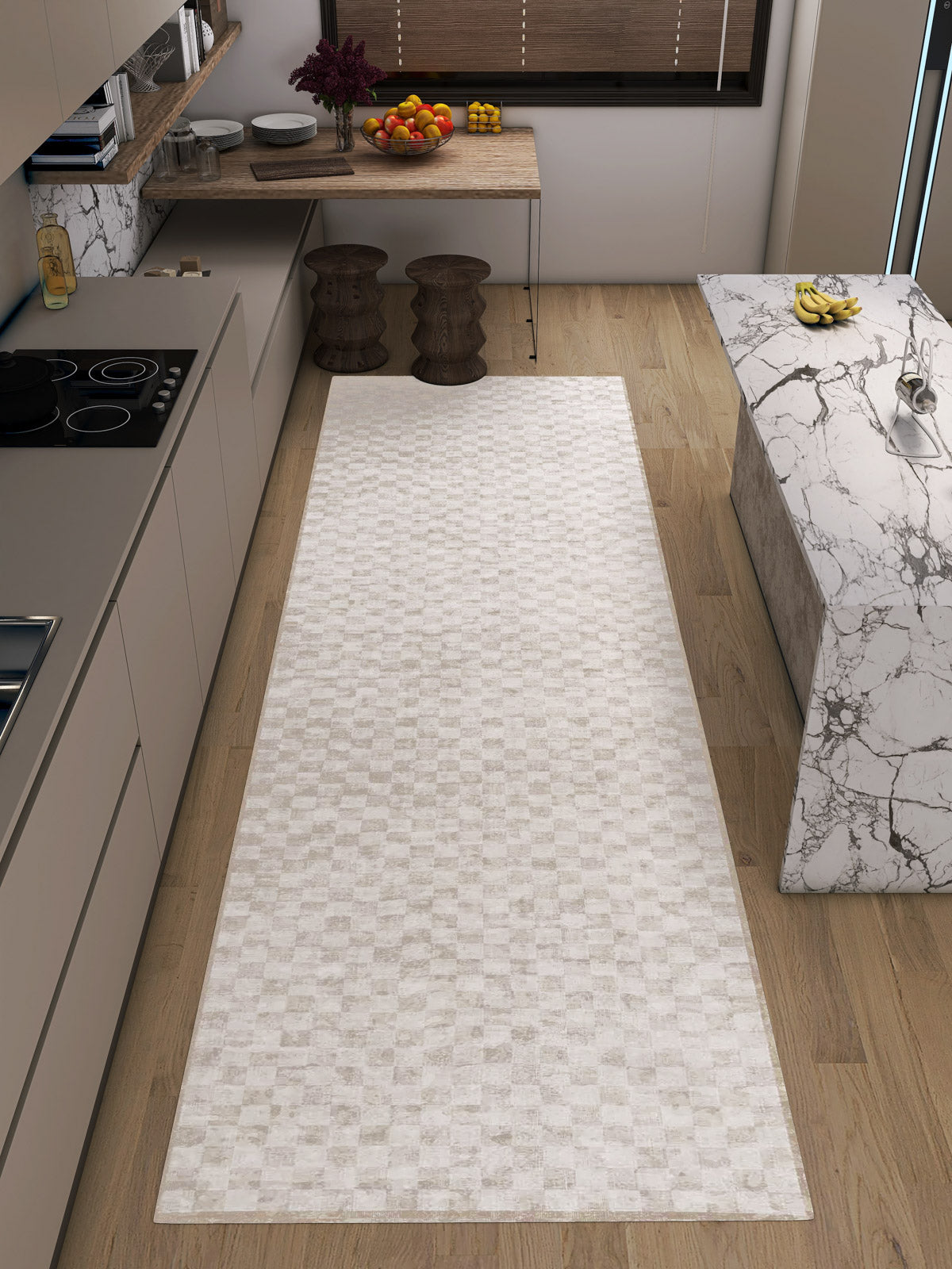 A modern kitchen with light wood flooring, neutral tones, a long Opulent Threads - Washable Rug - JRN27 ideal for high-traffic areas, beige cabinets, a marble island, and a table with fruit bowls and two wooden stools.