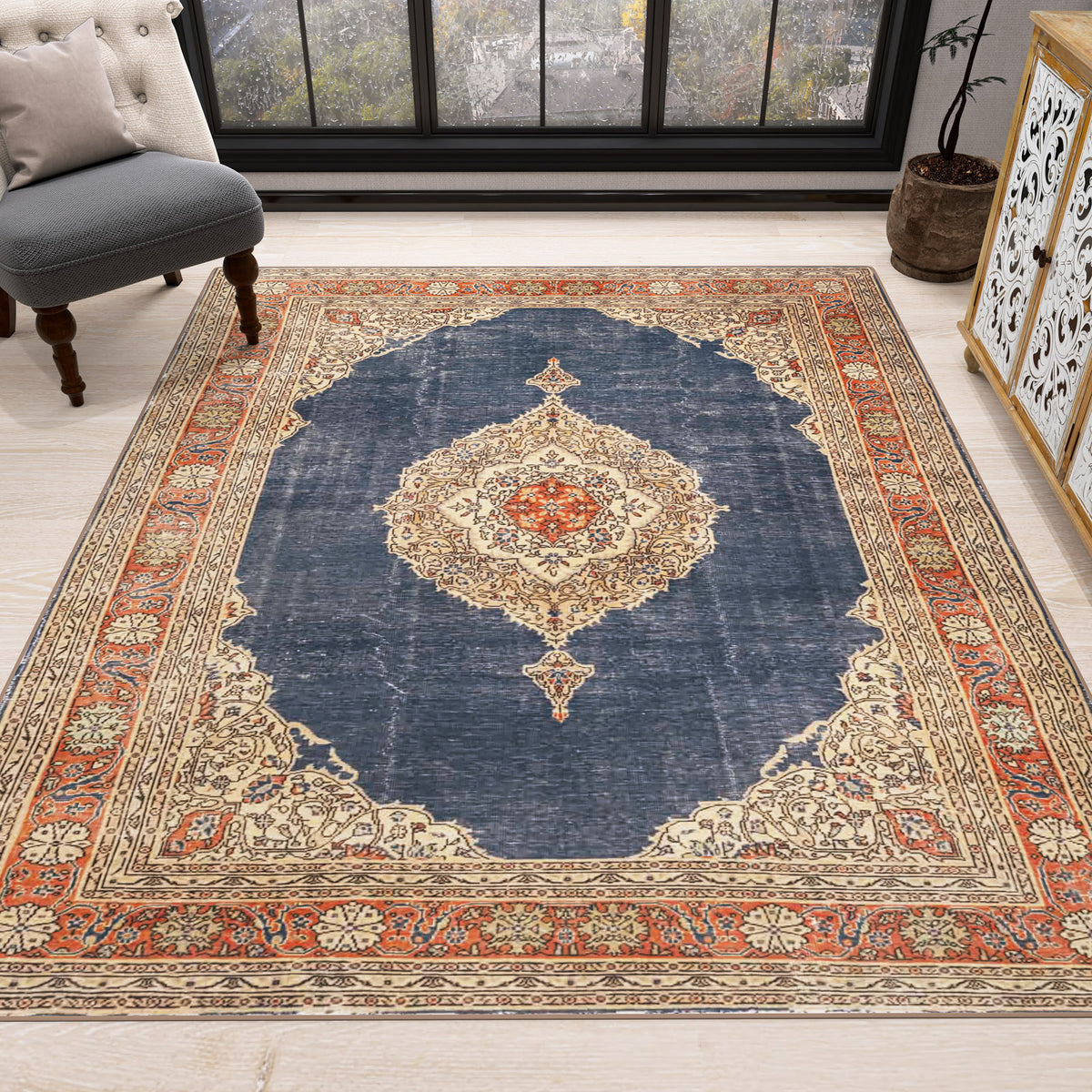 Navy blue traditional rug with a central cream medallion and orange floral border, styled in a living room.