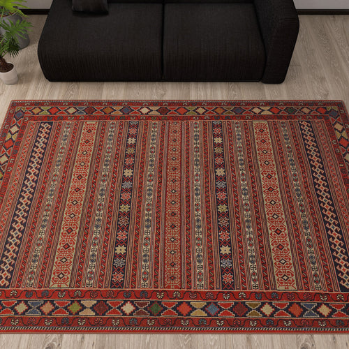 Load image 1 in gallery view. Red, navy, and tan striped rug with intricate geometric patterns, styled in a living room with a black sofa.