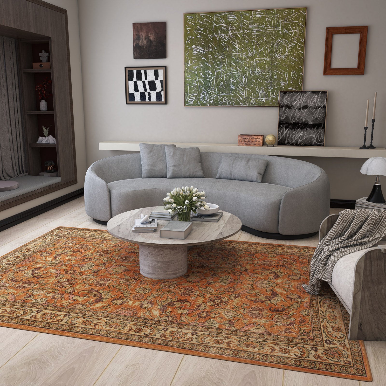 A modern living room with a curved gray sofa, round marble coffee table, and abstract art. The Celestial Vintage - Washable Rug - JRN1020 adds charm; white flowers and books rest on the table, and a throw blanket is draped over the sofa.