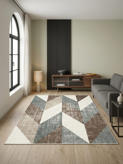 Load image 1 in gallery view. Blue, brown, and cream geometric chevron rug in a modern living room with wood floors and a grey sofa.
