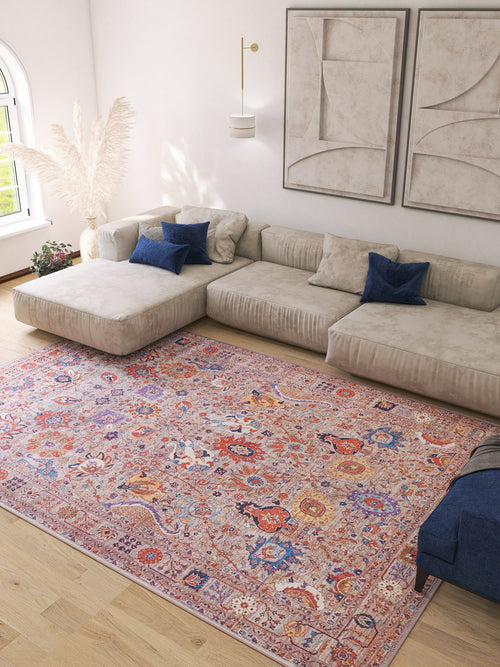 Bild 1 in Galerieansicht laden. A modern living room features a large beige sectional, blue pillows, abstract wall art, pampas grass in a vase, and the Velorio Floral Washable Rug - LCC3006—ideal for high-traffic and allergy-sensitive homes—on light wood floors by an arched window.