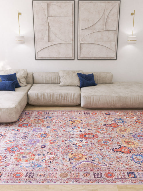 Load image 1 in gallery view. A modern living room with a light beige sectional, two blue accent pillows, abstract wall art, wall sconces, and the Velorio Floral Washable Rug - LCC3006 (Custom Size)—ideal for high-traffic areas—on a light wood floor.