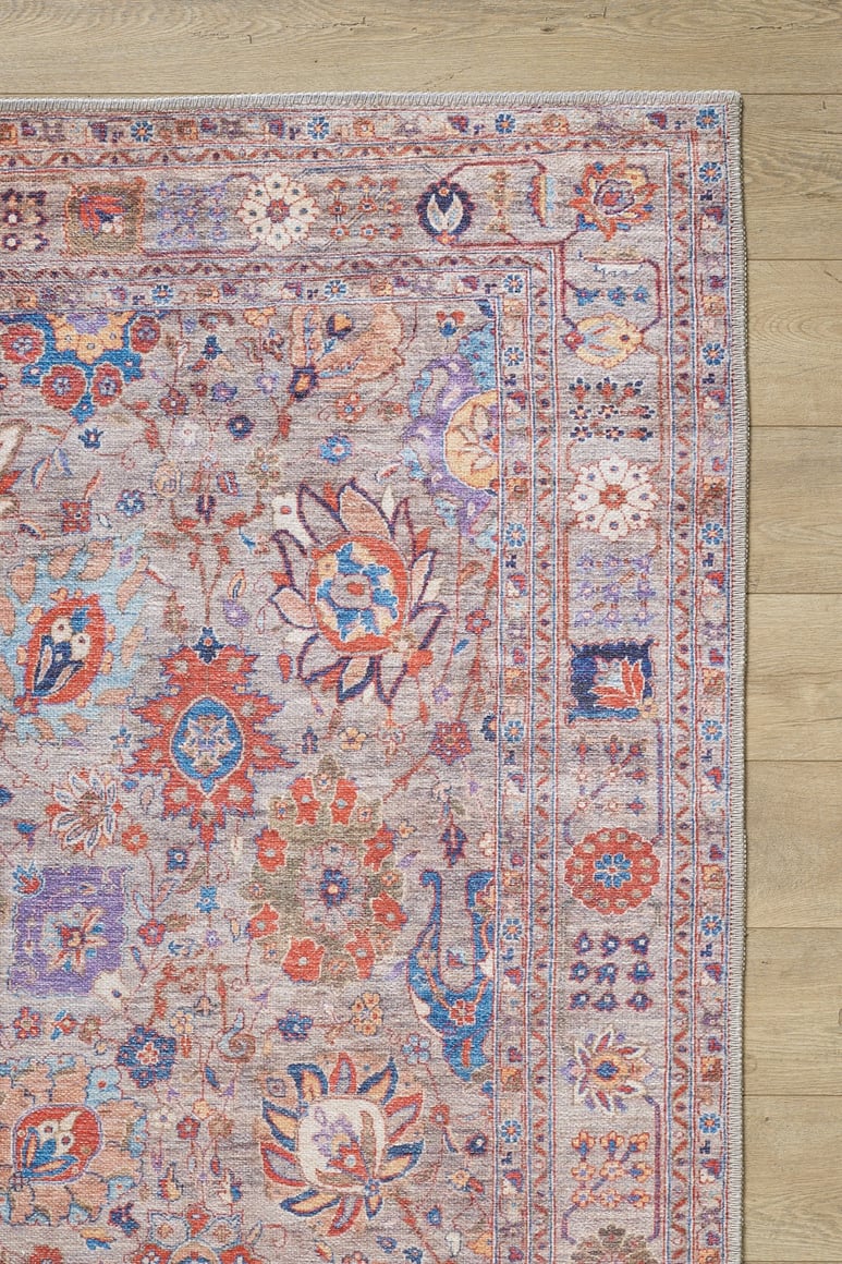 The Velorio Floral Washable Rug - LCC3006 (Custom Size) features intricate floral and geometric patterns in red, blue, orange, and cream on a light wooden floor—perfect for allergy-sensitive or high-traffic homes. Image shows the rug’s top right corner.