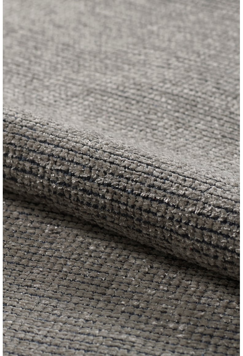 Close-up of the Velvet Touch Gray Area Rug - PST003 reveals its textured, woven grey fabric with subtle raised threads—perfect for fans of minimalist, modern rug design.