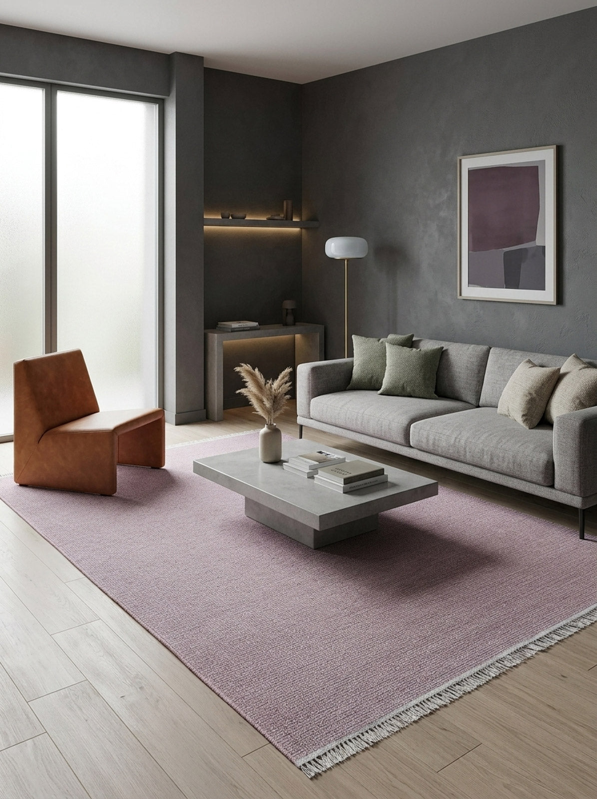 Minimalist living room with gray walls, modern gray sofa, light brown accent chair, concrete coffee table on a Velvet Touch Pink Area Rug - PST005, decorative vase, floor lamp, wall art, and sunlight through frosted windows.