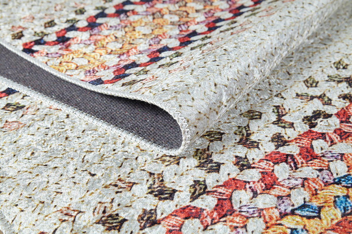 A close-up of the Vibrant Rainbow - Machine-Washable Rug (JR5001, Custom Size) shows its multicolored geometric pattern and textured stitching on a beige background—durable and ideal for high-traffic areas.