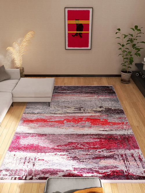 Load image 1 in gallery view. A modern living room with a white sectional sofa, the Vintage Brushed - Washable Rug - JR143 in pink and red, a corner plant, dried pampas grass, and framed cat artwork on the wall.