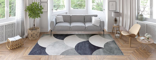 Bild 1 in Galerieansicht laden. A modern living room with a gray sofa, wooden furniture, potted plant, and large windows with sheer curtains features the Vivian Modern Washable Area Rug - MDJ010—ideal for allergy-sensitive households and high-traffic areas.
