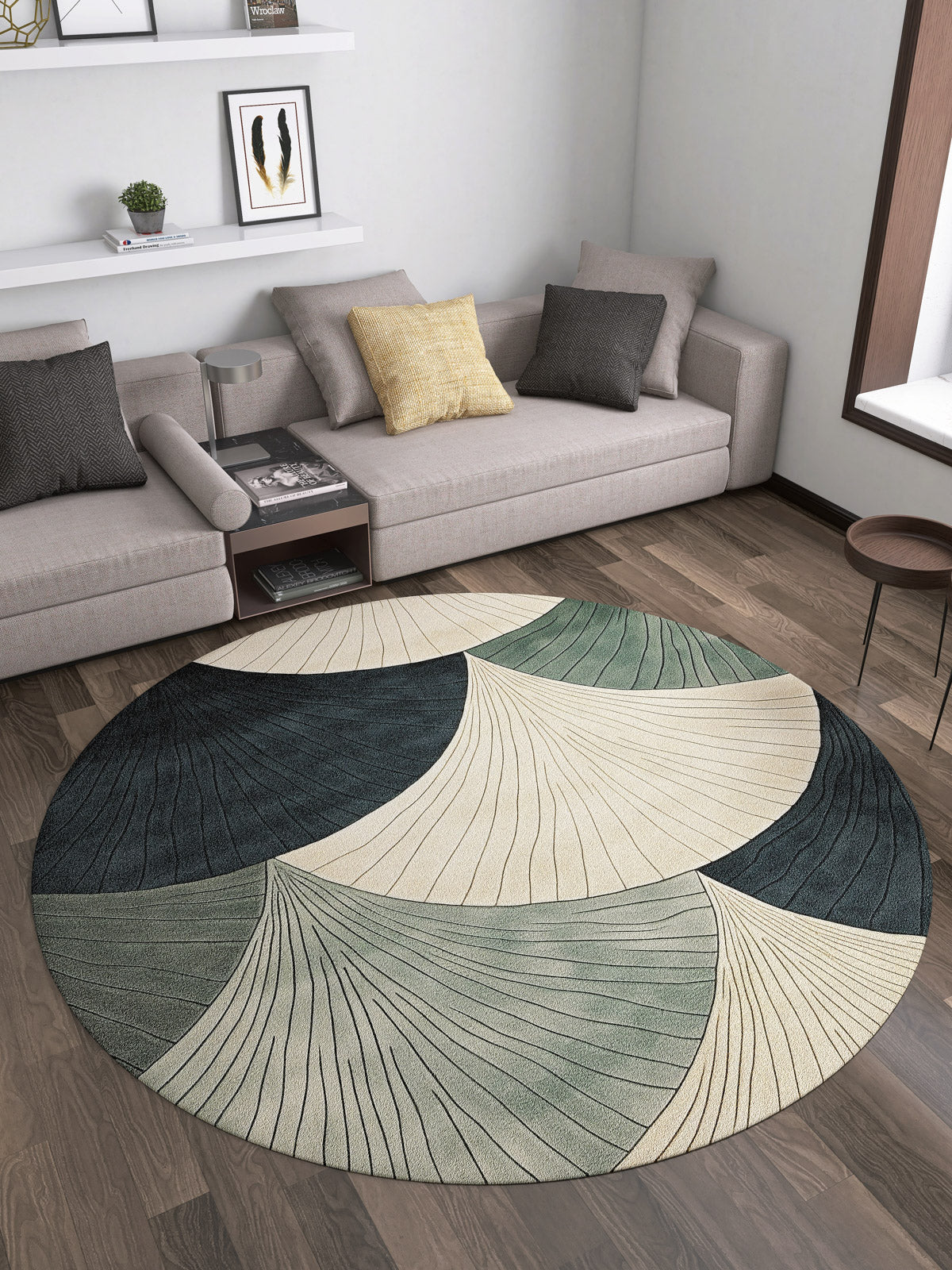 A modern living room featuring two beige sofas, a Vivian Modern Washable Area Rug - MDJ010 (custom size) with a circular abstract pattern in cream, green, and blue, a small round coffee table, and wall shelves with books and decor.
