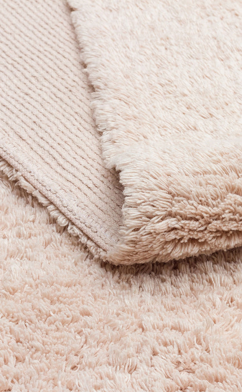 Bild 1 in Galerieansicht laden. A close-up of the Warm Sand - Washable Shaggy - CBNPLAIN rug shows its plush cream-beige surface and textured underside—ideal as a cozy, washable accent for any space.
