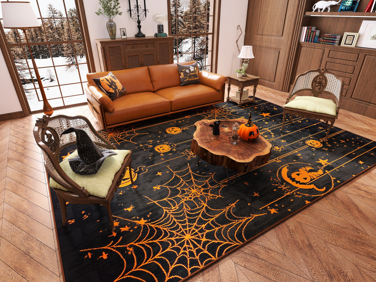 A cozy living room with a brown sofa and two armchairs centers around the Web Lights - Washable Rug - HLW007 (Custom Size), featuring orange spiderwebs and pumpkins—perfect for high-traffic areas, paired with witch hat décor and autumn views.