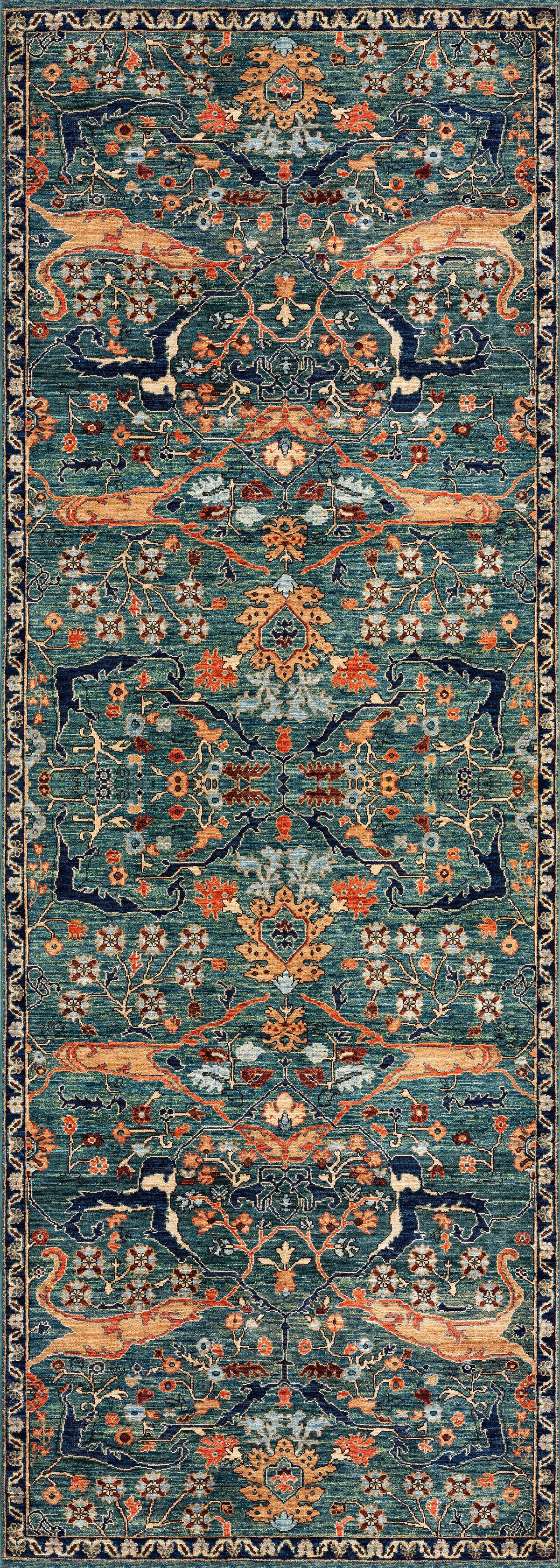 The Whisper Authentic Blue Washable Rug - LCC3034 is a rectangular, ornate blue rug with a symmetrical floral and vine pattern in blue, orange, gold, and beige, featuring a dark blue border—ideal for high-traffic areas.