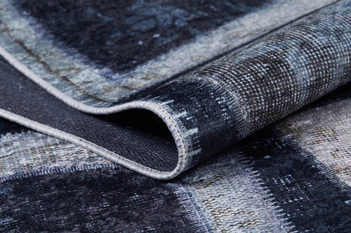 Load image 1 in gallery view. A close-up of the Windowpane Wonder - Washable Rug - JR184 (Custom Size) in dark gray-anthracite, featuring a geometric pattern with a folded corner that highlights texture and stitching—perfect for high-traffic areas.