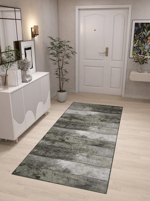 Load image 1 in gallery view. A modern entryway with light wood floors, a Wistful Pattern - Washable Rug - JRN35 (Custom Size) in gray-green, white door, potted plant, white console table with decor, wall sconce, and floral artwork on the wall.