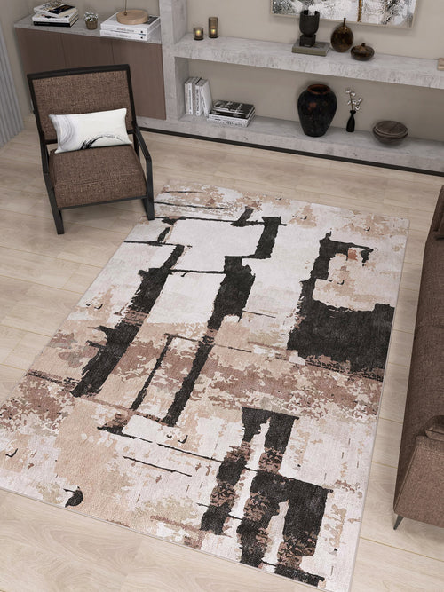 Load image 1 in gallery view. A modern living room with the Woven Memoir - Washable Rug - JRN41 in beige abstract pattern, a brown armchair with white pillow, brown sofa, wood floor, and minimalist shelves displaying decor items and books.
