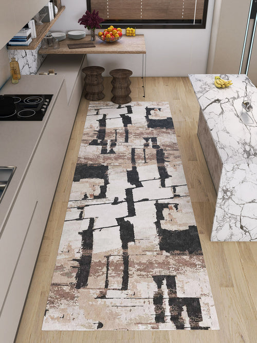 Load image 1 in gallery view. A modern kitchen with light wood floors, a marble island, two wooden stools, and the Woven Memoir - Washable Rug - JRN41 in abstract beige, brown, and black—durable for high-traffic areas. Fruit bowls add a stylish touch to the counters.