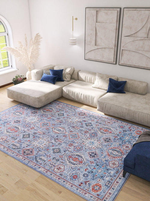 Load image 1 in gallery view. A modern living room with a beige sectional, blue accent pillows, abstract art, light wood floors, and the Xanadu Handmade-Design Blue Washable Rug – LCC3013—ideal for high-traffic areas. Pampas grass in a vase decorates the corner.