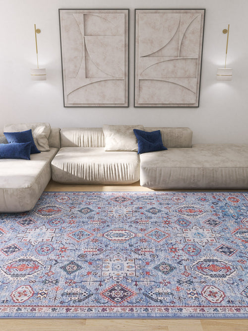 Load image 1 in gallery view. A modern living room featuring a cream sectional sofa, blue accent pillows, two abstract beige wall art pieces, wall-mounted lights, and the Xanadu Handmade-Design Blue Washable Rug - LCC3013 (Custom Size).