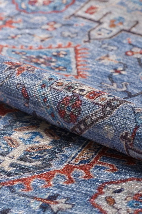 Load image 1 in gallery view. Close-up of the Xanadu Handmade-Design Blue Washable Rug - LCC3013 (Custom Size), featuring intricate red, white, and navy patterns. The slightly folded rug highlights its detailed flat weave texture and woven motifs.