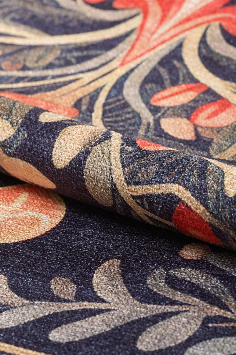 Close-up of the Xmas Tree Washable Area Rug - MDJ005, featuring an intricate, colorful floral pattern in navy blue, gold, beige, and red. The richly woven texture is designed for durability in high-traffic areas.