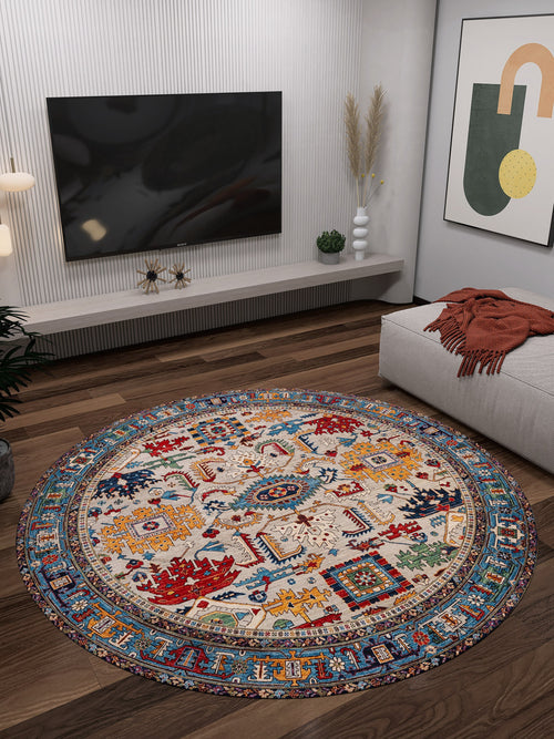 Load image 1 in gallery view. A modern living room features the Yonder Blue Cream Washable Rug - LCC3045 on dark wood floors, a wall-mounted TV, low shelf with decor, gray sofa with rust throw, and abstract art—perfect for high-traffic spaces.