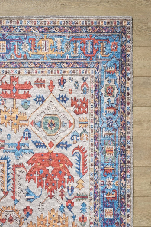 Load image 1 in gallery view. The Yonder Blue Cream Washable Rug - LCC3045 showcases vibrant multicolor patterns in red, blue, yellow, and white on a light wooden floor. With symmetrical motifs and ornate borders, it's perfect for high-traffic areas and adds a stylish touch.