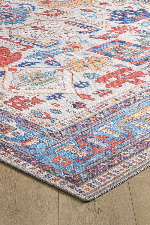 Load image 1 in gallery view. A close-up of the Yonder Blue Cream Washable Rug - LCC3045 shows intricate red, blue, yellow, and orange designs on a light background with detailed borders—perfect for high-traffic areas and displayed on a wooden floor.
