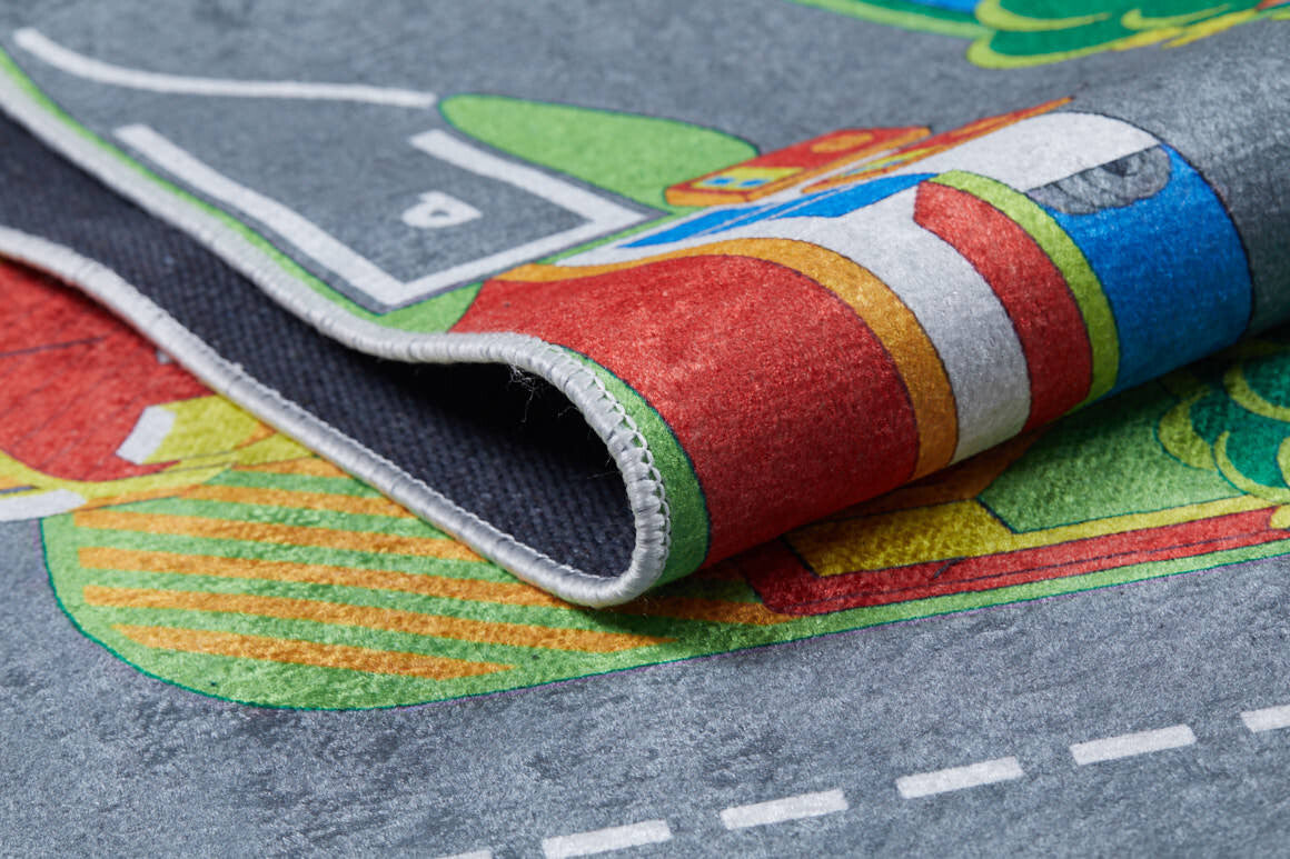 Close-up of the Zooming Metropolis - Machine-Washable Rug JRC012 (Custom Size) showing a folded corner, detailed edge stitching, and vibrant city roads. This bright, washable rug suits high-traffic kids' rooms with its playful patterns.
