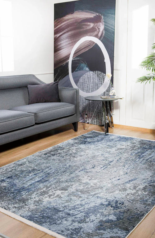 Bild 1 in Galerieansicht laden. A modern living room features a gray sofa, abstract artwork with a white circle, a small side table, a potted plant, and the Abstract Oasis - Washable Rug - JR144 (Outlet) US—an allergy-friendly, washable option for high-traffic wooden floors.